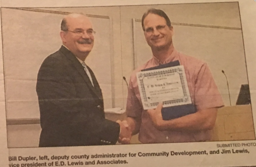 Bill Dupler, deputy county administrator for Community Development, presenting the award certificate to Jim Lewis, vice president of E.D. Lewis and Associates