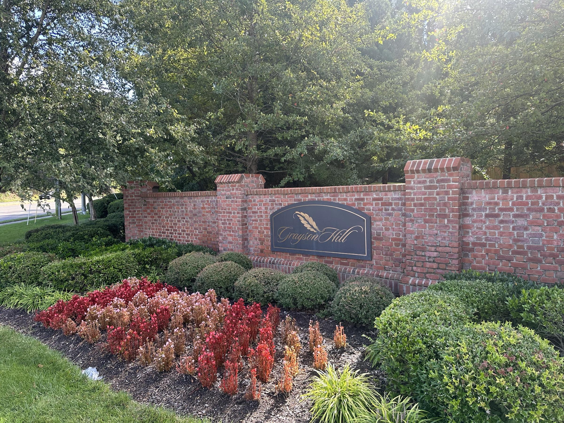 The brick Grayson Hill entrance wall with flower beds