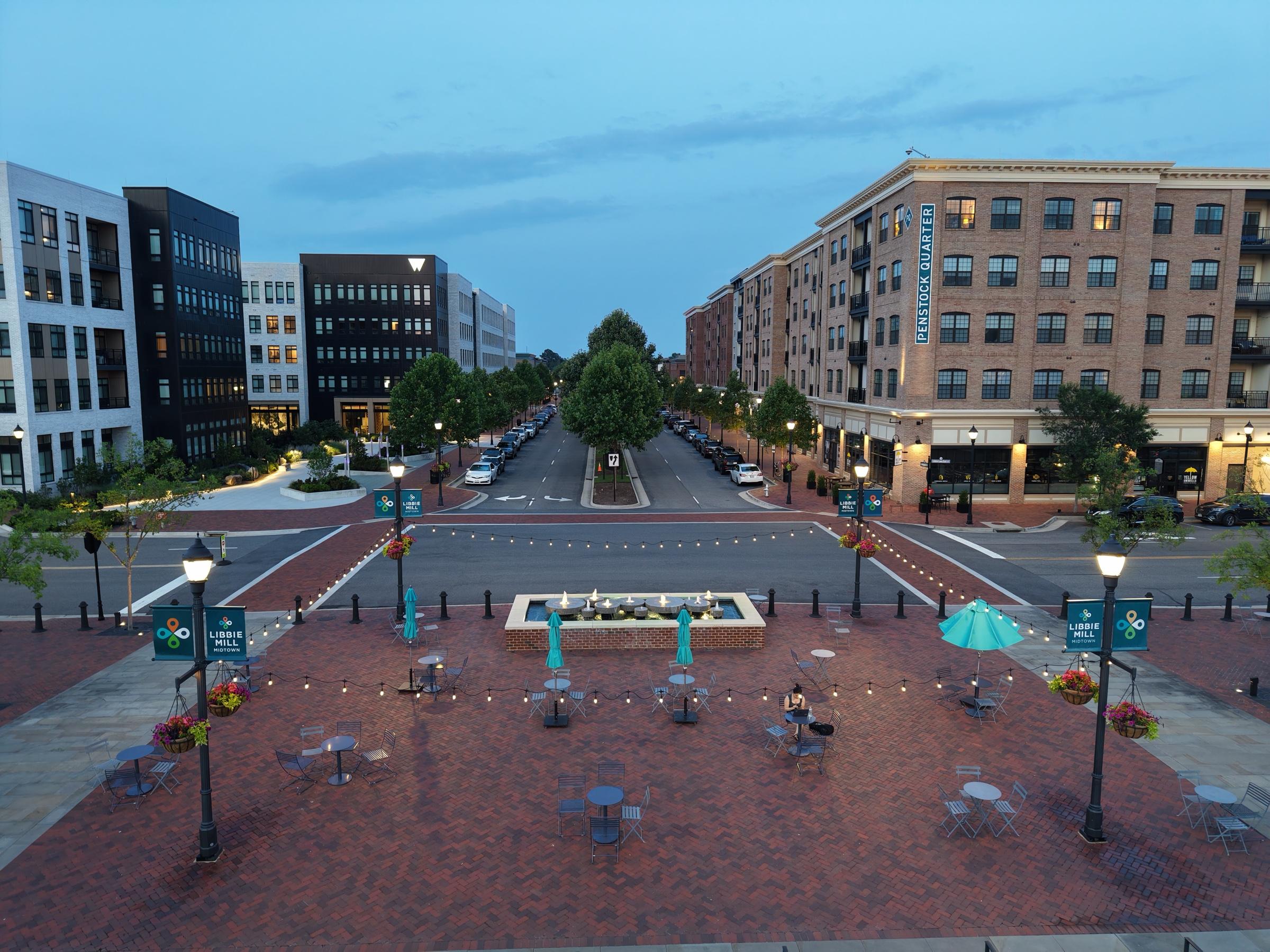 The brick plaza at Libbie Mill at dusk, framed by apartment and office buildings