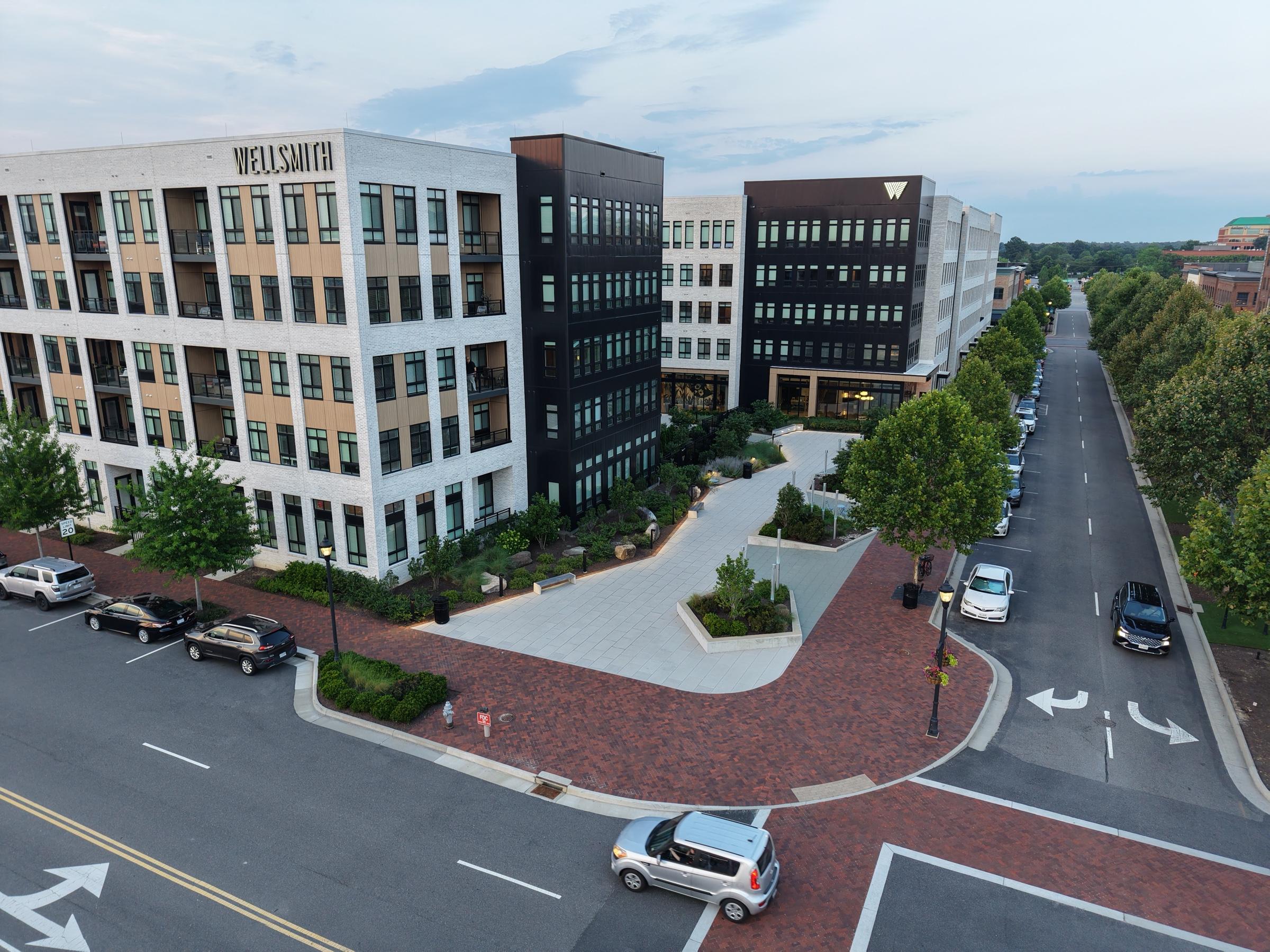 Office buildings, a brick crosswalk and tree-lined street at Libbie Mill
